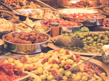 Güney İtalya Catania 'nın tipik ürünlerine yakın çekim. Bu baharatlı zeytinlerin, yağlı enginarların, kurutulmuş domateslerin ve diğer lezzetli Sicilya spesiyallerinin arasında. Yatay görünüm