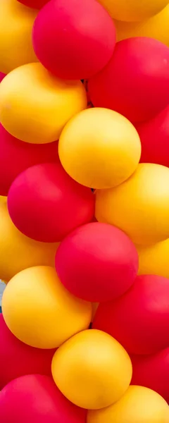 Row of red and yellow balloons forming a column about two meters high. Vertical view