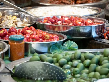 Güney İtalya Catania 'nın tipik ürünlerine yakın çekim. Bu baharatlı zeytinlerin, yağlı enginarların, kurutulmuş domateslerin ve diğer lezzetli Sicilya spesiyallerinin arasında. Yatay görünüm