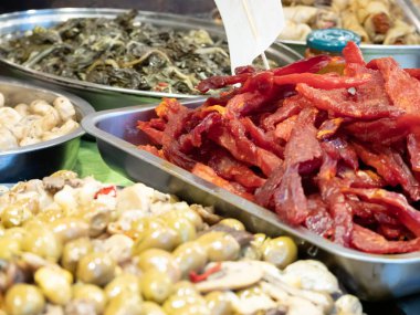 Güney İtalya Catania 'nın tipik ürünlerine yakın çekim. Bu baharatlı zeytinlerin, yağlı enginarların, kurutulmuş domateslerin ve diğer lezzetli Sicilya spesiyallerinin arasında. Yatay görünüm