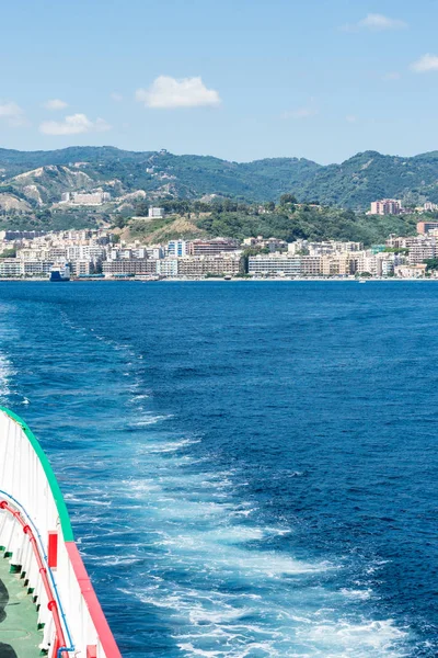 Bir araba stern denizden görünümünü feribot Messina Boğazı ve arka planda Messina şehri. Dikey görünüm