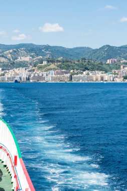 Bir araba stern denizden görünümünü feribot Messina Boğazı ve arka planda Messina şehri. Dikey görünüm