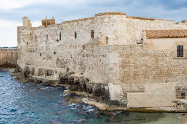 Ortigia Syracuse 'daki deniz ve gökyüzünün önündeki Maniace kalesinin güzel manzarası. Yatay görünüm