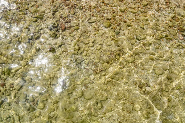 Bovenaanzicht van zee wateroppervlak met kleine rock — Stockfoto
