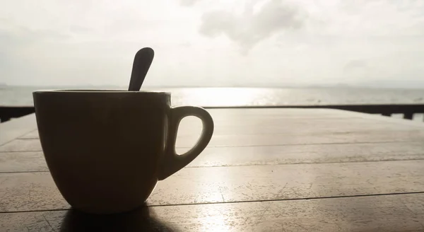 Closeup coffee cup at beach cafe in silhouette — Stock Photo, Image