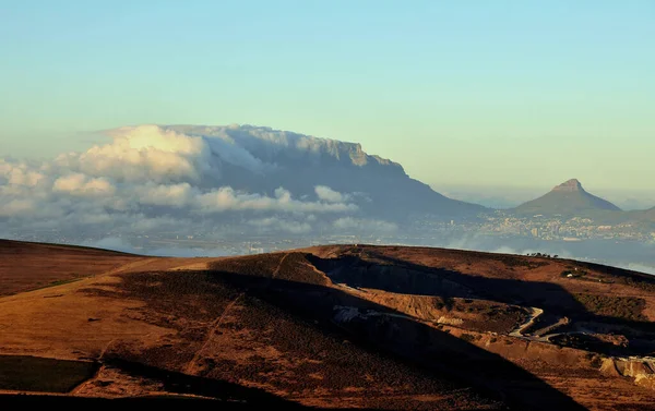Durbanville Hills 'ten, karakteristik bulut örtüsü ve Cape Town' un ayaklarının dibinde yürüdüğü ikonik Masa Dağı 'na doğru uzanan fynbos bitki örtüsü üzerinde Lions Head sağda kasıla kasıla yürüyordu..