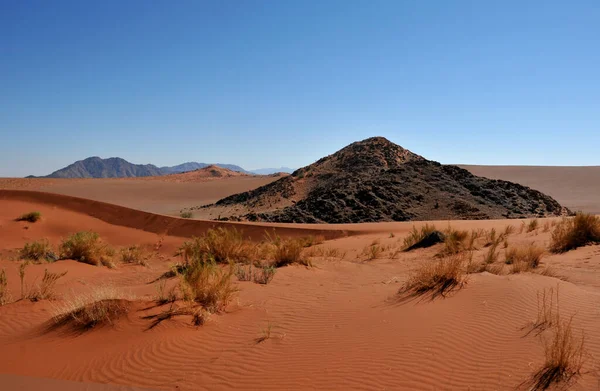 在纳米布沙漠 红色的铁质沙子和岩石般的露头尚未磨成沙子 与蓝天形成鲜明对比 — 图库照片