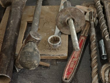 Çalışma tezgahına yerleştirilmiş eski metal aletler anahtar, cıvata ve çubuklar gibi eski metal aletler..