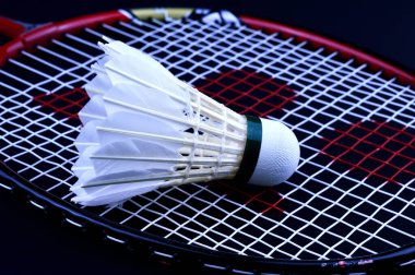 Bir beyaz badminton topu raketin üzerinde