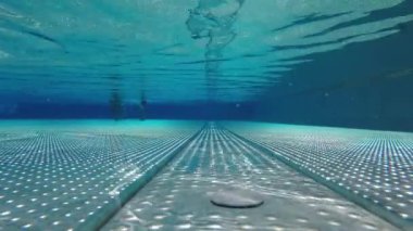 Havuzun dibinde yürüyor.