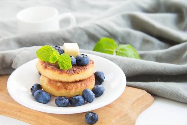 A healthy breakfast of pancakes, berries, butter, and honey