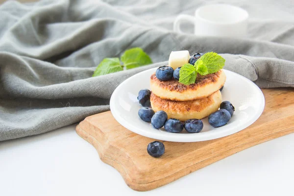 A healthy breakfast of pancakes, berries, butter, and honey