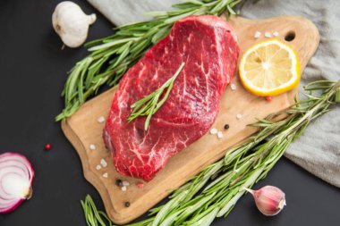 Kesme tahtasında baharatlı çiğ biftek. Yaratıcı atmosfer dekorasyonu.