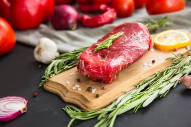 Kesme tahtasında baharatlı çiğ biftek. Yaratıcı atmosfer dekorasyonu.