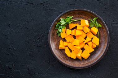 Çok güzel doğranmış balkabağı dilimleri, bitkiler ve yemek için malzemeler. Yaratıcı atmosfer dekorasyonu