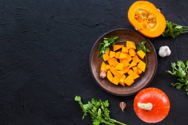 Çok güzel doğranmış balkabağı dilimleri, bitkiler ve yemek için malzemeler. Yaratıcı atmosfer dekorasyonu