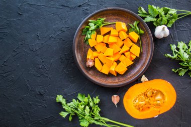 Çok güzel doğranmış balkabağı dilimleri, bitkiler ve yemek için malzemeler. Yaratıcı atmosfer dekorasyonu