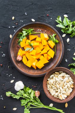 Çok güzel doğranmış balkabağı dilimleri, bitkiler ve yemek için malzemeler. Yaratıcı atmosfer dekorasyonu