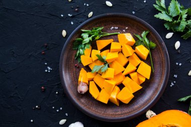 Çok güzel doğranmış balkabağı dilimleri, bitkiler ve yemek için malzemeler. Yaratıcı atmosfer dekorasyonu