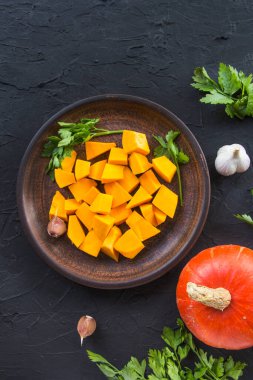 Çok güzel doğranmış balkabağı dilimleri, bitkiler ve yemek için malzemeler. Yaratıcı atmosfer dekorasyonu