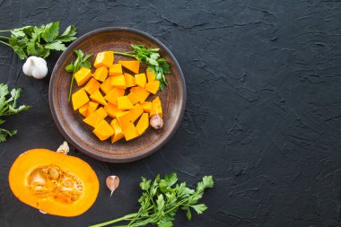 Çok güzel doğranmış balkabağı dilimleri, bitkiler ve yemek için malzemeler. Yaratıcı atmosfer dekorasyonu