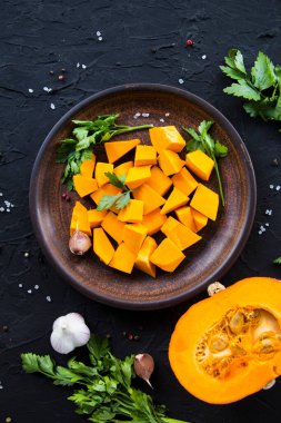 Çok güzel doğranmış balkabağı dilimleri, bitkiler ve yemek için malzemeler. Yaratıcı atmosfer dekorasyonu