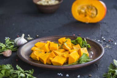 Çok güzel doğranmış balkabağı dilimleri, bitkiler ve yemek için malzemeler. Yaratıcı atmosfer dekorasyonu