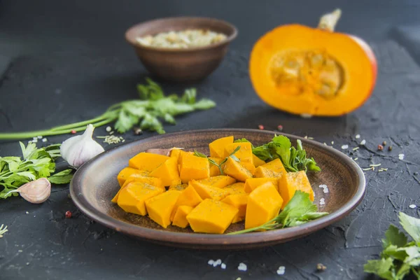 Çok güzel doğranmış balkabağı dilimleri, bitkiler ve yemek için malzemeler. Yaratıcı atmosfer dekorasyonu