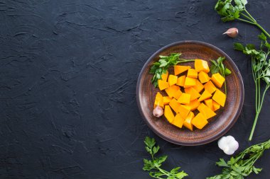 Çok güzel doğranmış balkabağı salatası, şifalı otlar ve yemek için malzemeler. Yaratıcı atmosfer dekorasyonu