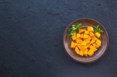 Çok güzel doğranmış balkabağı salatası, şifalı otlar ve yemek için malzemeler. Yaratıcı atmosfer dekorasyonu