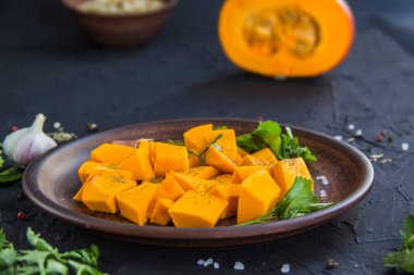 Çok güzel doğranmış balkabağı salatası, şifalı otlar ve yemek için malzemeler. Yaratıcı atmosfer dekorasyonu