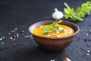 Lezzetli sağlıklı balkabağı çorbası, bitkiler ve yemek için malzemeler. Yaratıcı atmosfer dekorasyonu