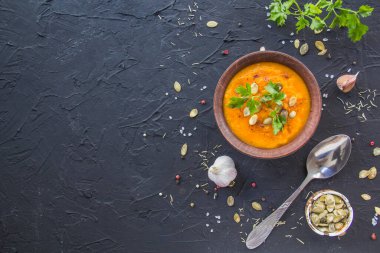 Lezzetli sağlıklı balkabağı çorbası, bitkiler ve yemek için malzemeler. Yaratıcı atmosfer dekorasyonu