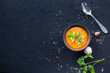 Lezzetli sağlıklı balkabağı çorbası, bitkiler ve yemek için malzemeler. Yaratıcı atmosfer dekorasyonu