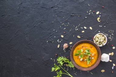 Lezzetli sağlıklı balkabağı çorbası, bitkiler ve yemek için malzemeler. Yaratıcı atmosfer dekorasyonu