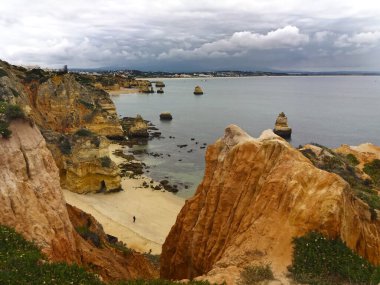 Portekiz, Algarve 'deki Lagos kıyılarında, kasvetli bir günde, kayalar ve kıyıda bir adam