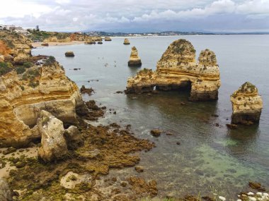 Atlantik Okyanusu manzarası ve okyanustaki kayalar Lagos 'ta bulutlu bir günde mavi ve gri bulutlarla