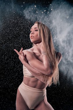 Tiyatroda pudrayla poz veren kadın dansçı. Siyah arkaplan