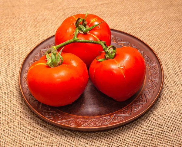 Una Ramita Tres Tomates Rojos Una Bandeja Barro Plato Está — Foto de Stock