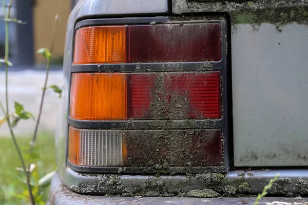 被遗弃的80年代汽车前灯布满了苔藓锈蚀的近景 — 图库照片