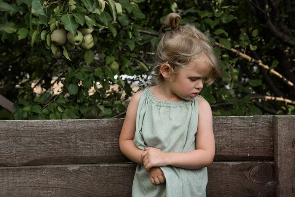 Küçük kız düşünceli bir şekilde aşağıya bakıyor.