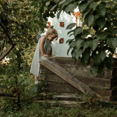 Küçük kız düşünceli bir şekilde aşağıya bakıyor.