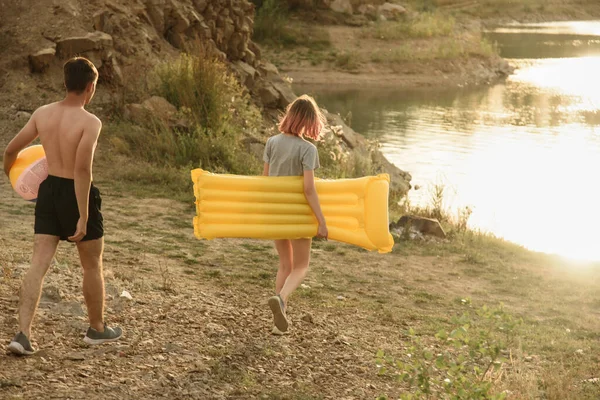 Bir grup genç insan göl boyunca yürüyor.