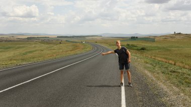 Genç bir adam bir araba yakalar.