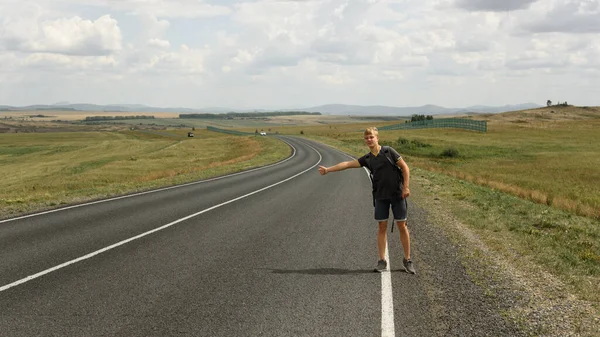 Genç bir adam bir araba yakalar.