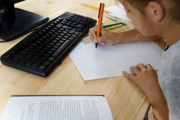 Liseli kız bilgisayarın önünde ders veriyor.