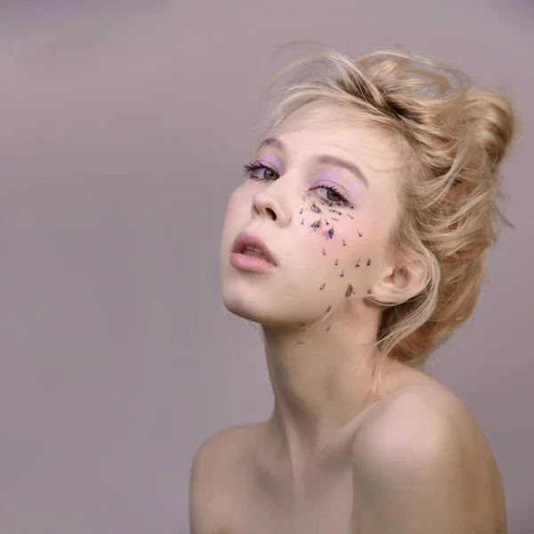 Sarışın, eflatun renginde. Çiçeklerden yapılmış gözyaşları.