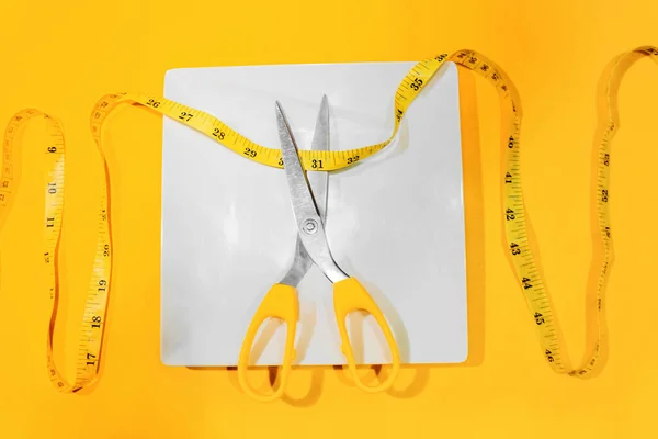 Showing excess weight gain around the waist with a tailor\'s tape measure. Recommended diet plan.
