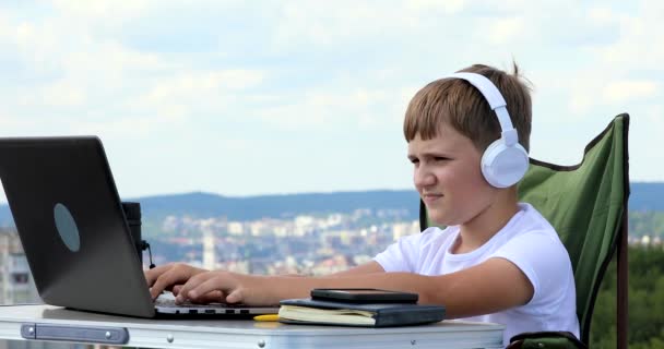 Pojken Studerar Vid Datorn Hörlurar Och Slår Musiken Telefonen — Stockvideo