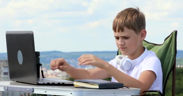 Niño Sienta Trabajar Portátil Escribe Datos Desde Monitor Portátil — Vídeos de Stock